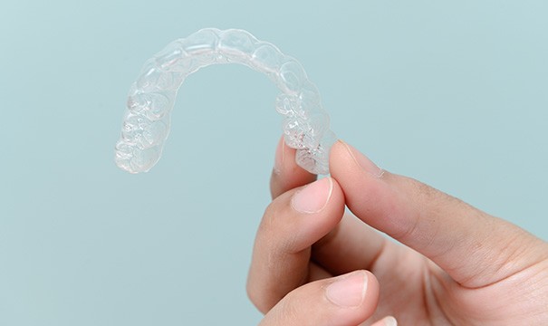 Closeup of patient holding clear aligner