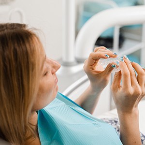 Closeup of patient holding clear aligner in treatment room