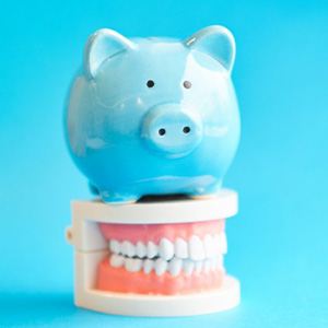 Piggy bank sitting on top of plastic model teeth