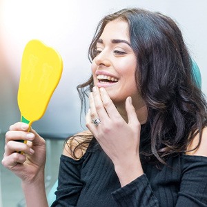 Woman smiling while looking at reflection in mirror